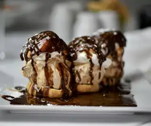 Coffee Ice Cream Profiteroles With Chocolate Sauce and Whipped Cream.